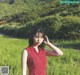 A woman in a red dress standing in a field.