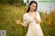 A woman in a white dress standing in a field of yellow flowers.