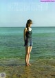 A woman standing in the water at the beach.