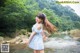 A woman in a blue and white dress standing in a river.