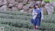 A woman in a school uniform standing in a field.