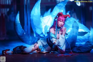 A woman in a blue and white outfit laying on the ground.