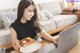 A woman sitting at a table with a plate of toast and a laptop.