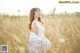 a woman in a white dress sitting in a field