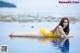 A woman in a yellow bikini laying on the water.