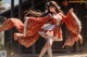 A woman in a red and white dress dancing in front of a building.